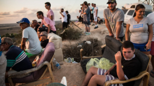 Coloni israeliani appostati sulle colline attorno a Gaza ad osservare mentre viene bombardata nel 2014